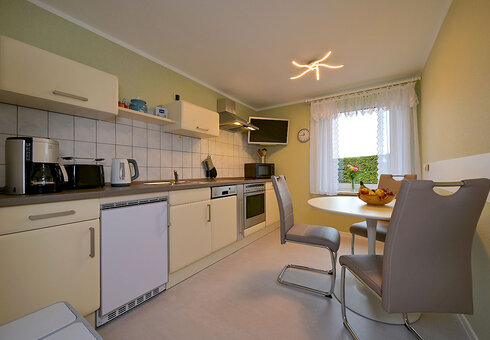 voll ausgestatte Küche mit Esstisch