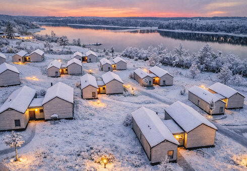 Schneebedecktes Winterdorf am See