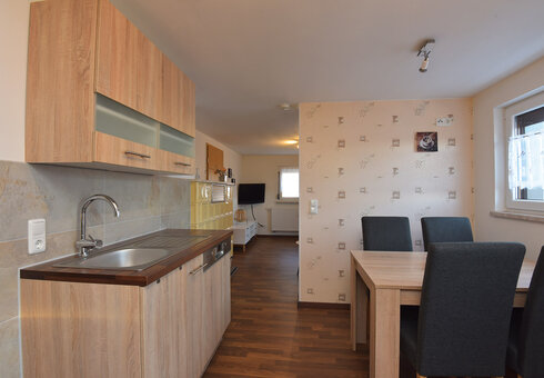 Küche mit Esstisch und Blick in das Wohnzimmer