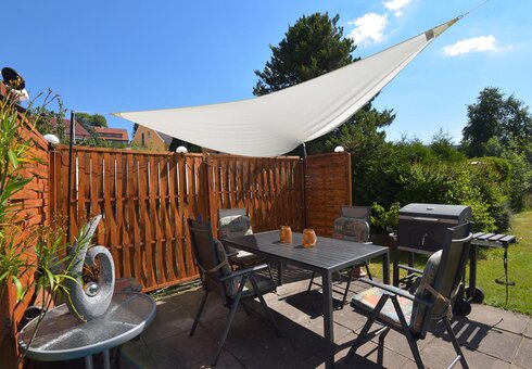 Terrasse mit Gartenmöbeln und Grill